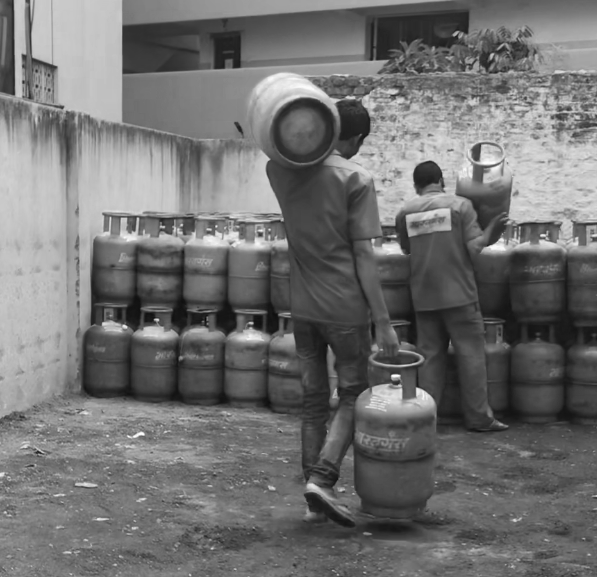 two men carrying and stacking cylinders