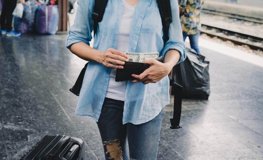 woman putting cash in wallet at airport