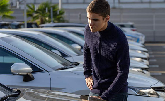 guy inspecting car in parking lot