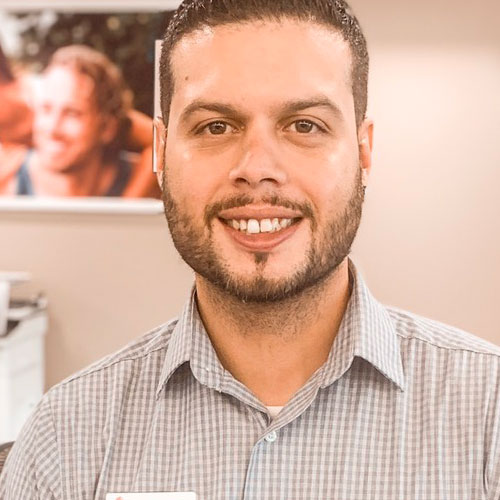 portrait of smiling and welcoming male SunWest branch representative at teller station