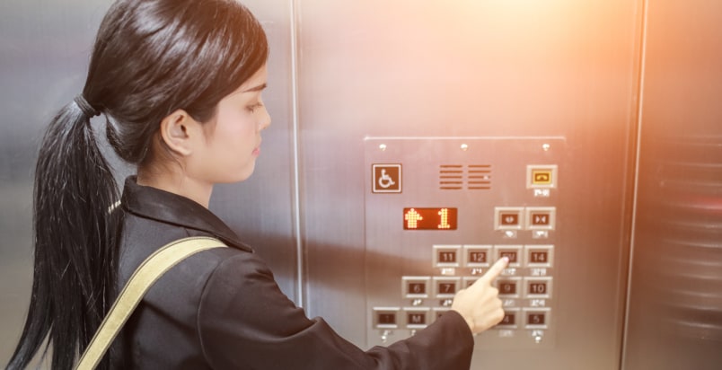 woman pushing elevator button
