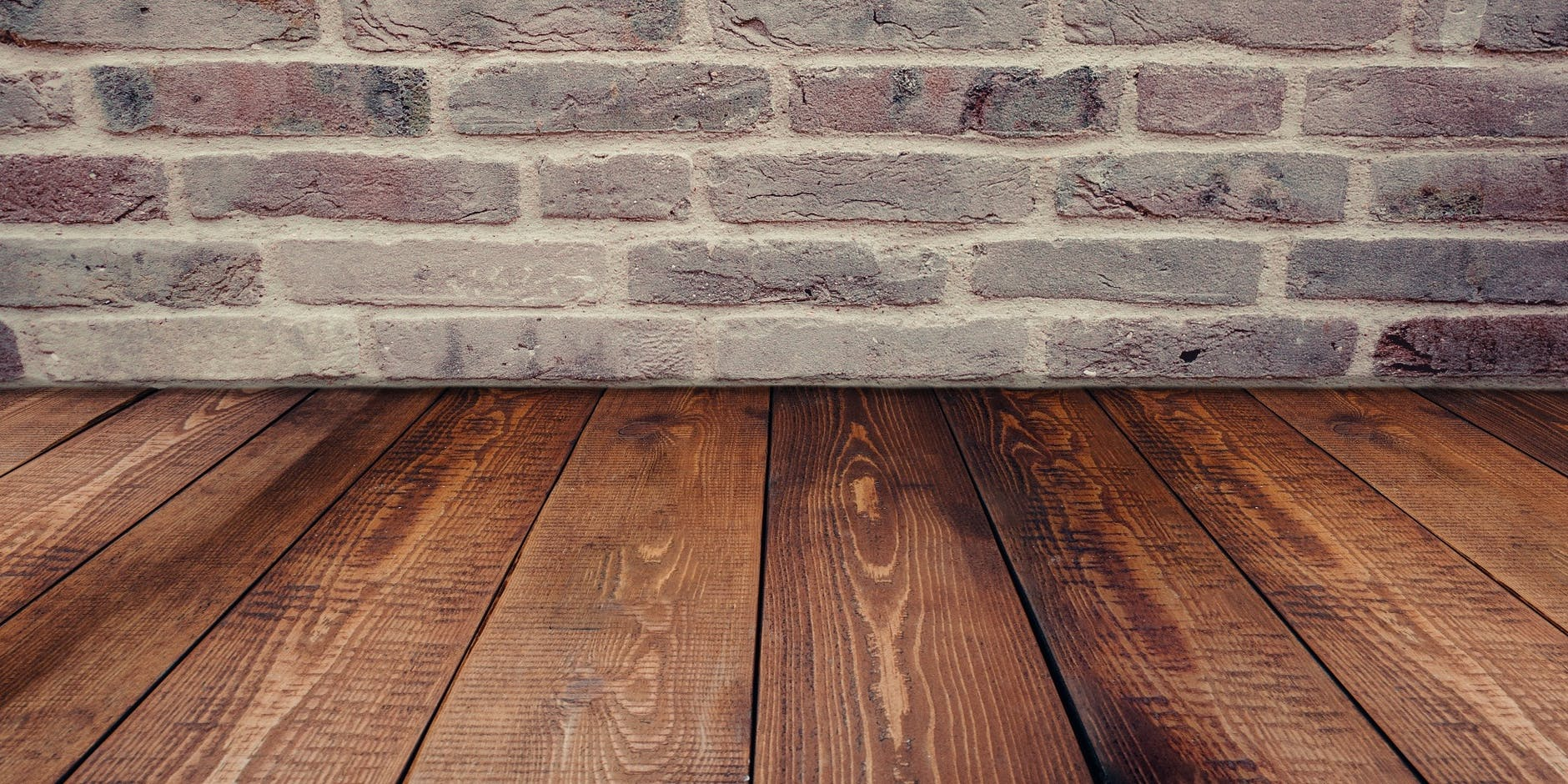reclaimed wooden planks on floor with brick wall
