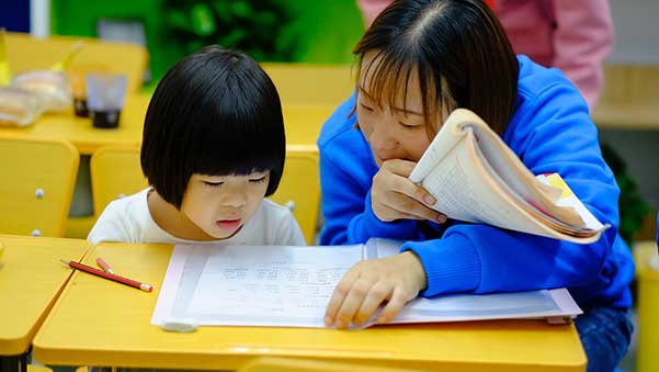 An educational assistant from ABM College works with a student on her practicum