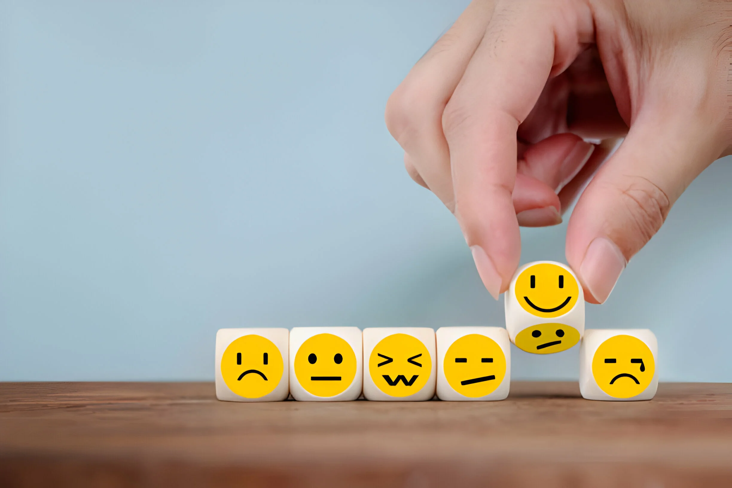 Woman picking up a smiling cube representing the character she's choosing 