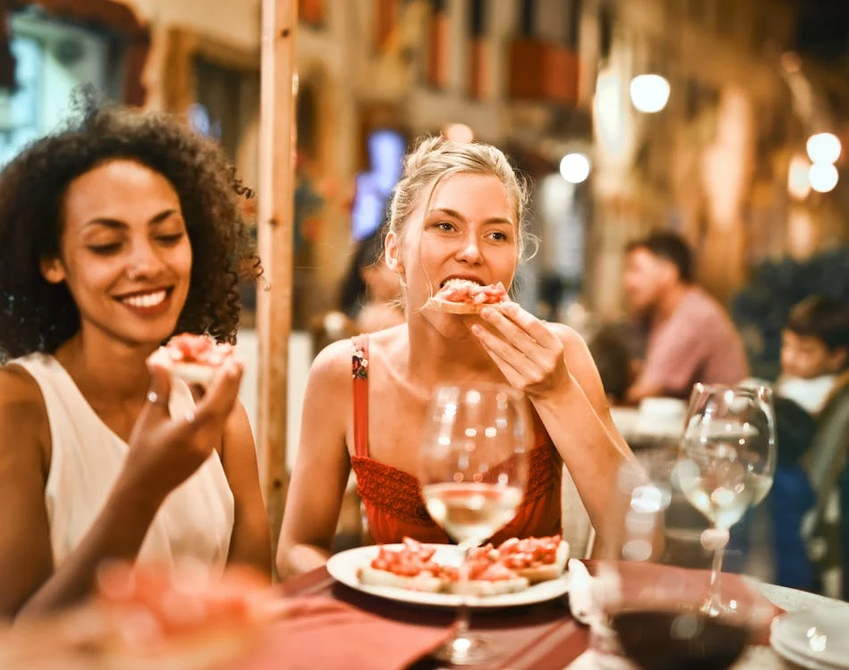 two friends eating bread outside