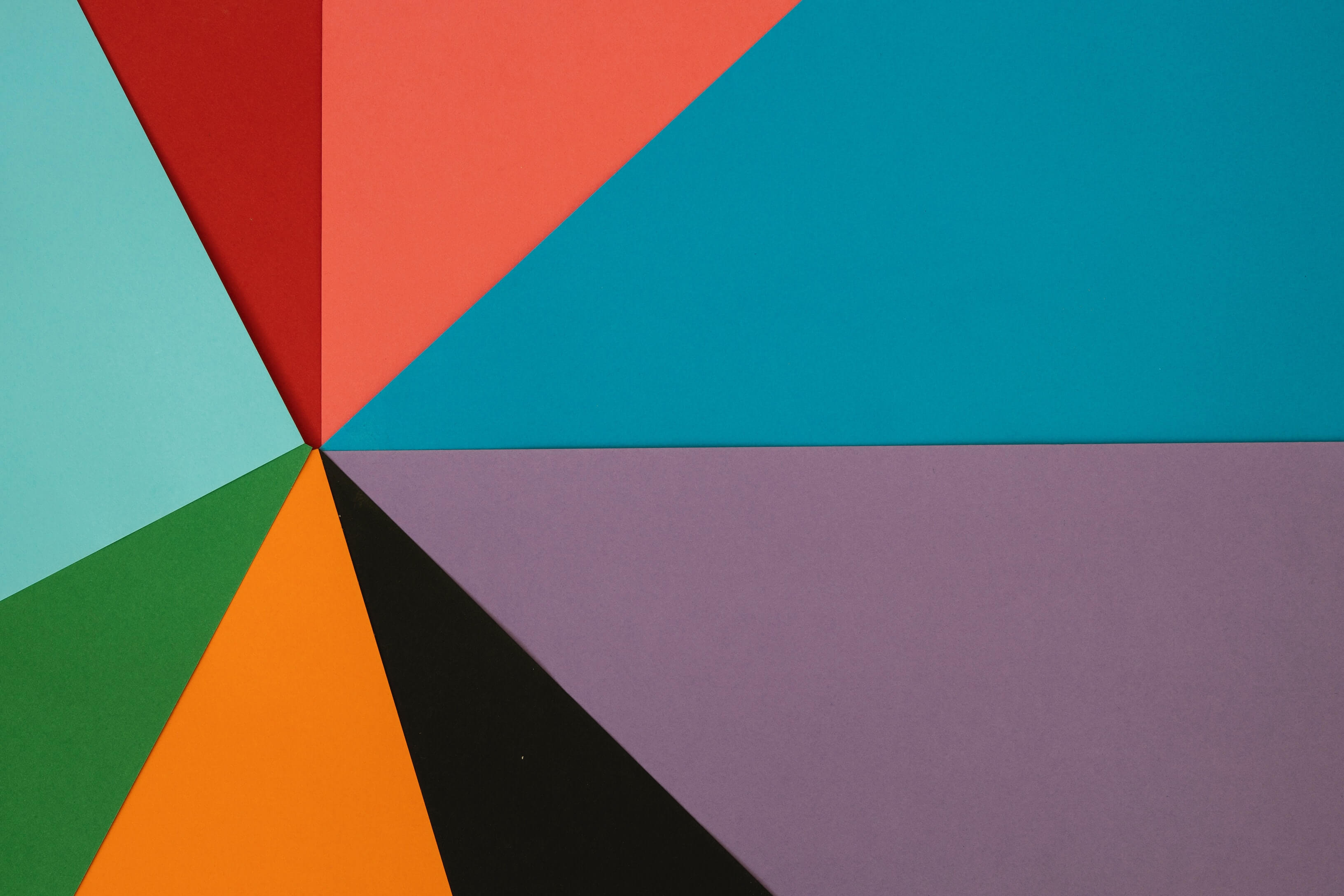 Colorful, trianglar pieces of construction paper arranged in a pattern.