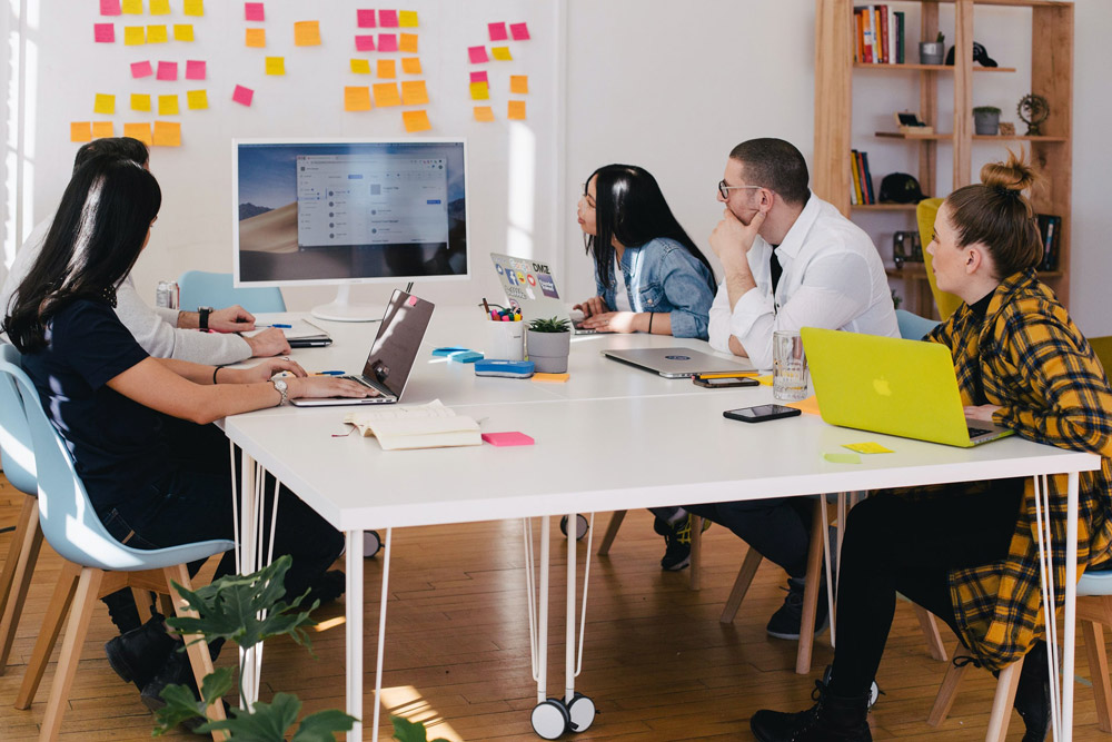 Diverse team utilizing their hybrid workplace office.