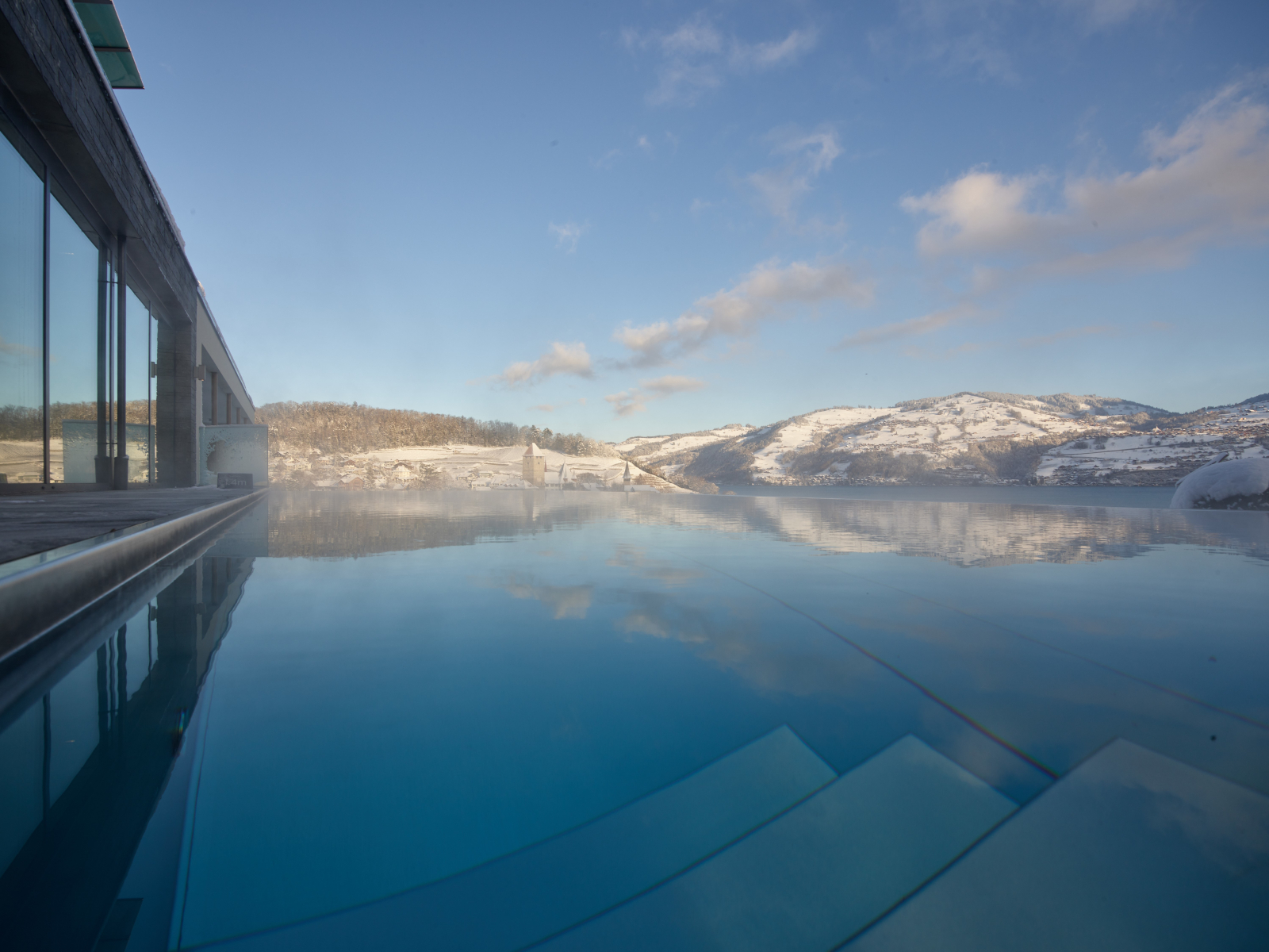 Frau in Infinity Pool mit Sicht auf den Thunersee