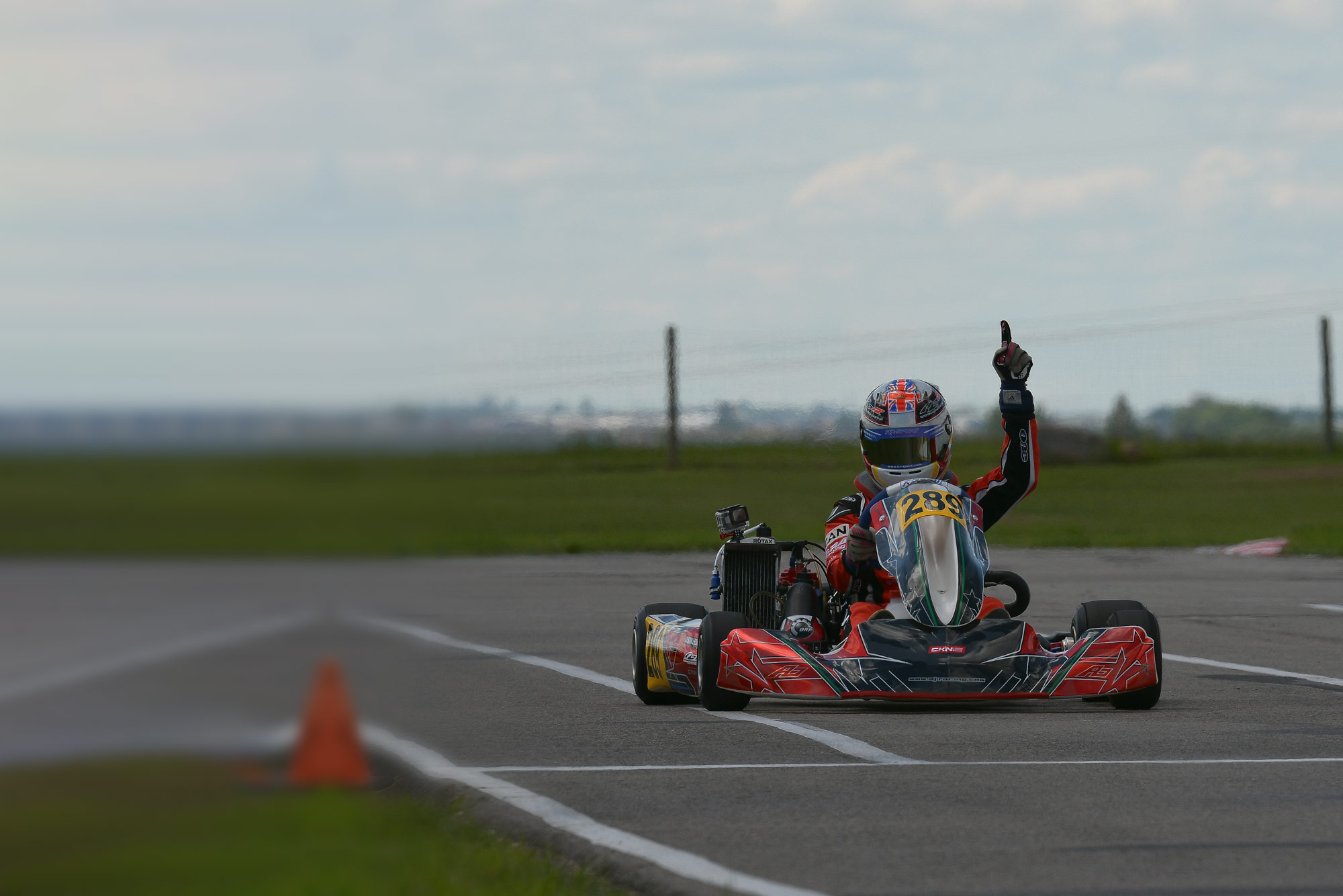 Black Racing Engine photo of kart driver pointing to the sky