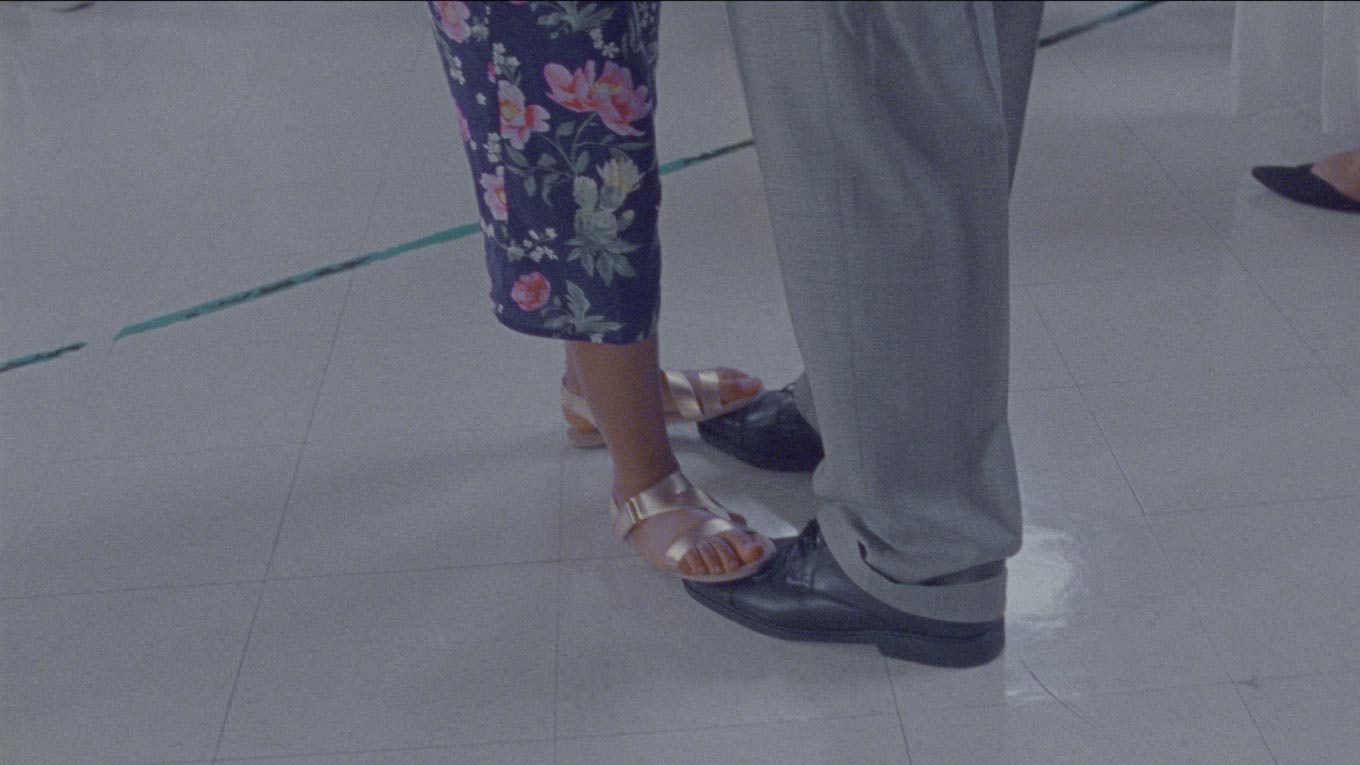 A still from the movie "Daughters," where a little girl's feet are on top of her father's during a dance