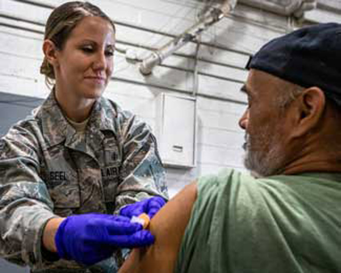 U.S. Air Force Tech. Sgt. Melissa A. Seel, puts an adhesive bandage on a homeless veteran during the Sgt. 1st Class Robert H. Yancey Sr. Stand Down at the National Guard armory in Cherry Hill, New Jersey