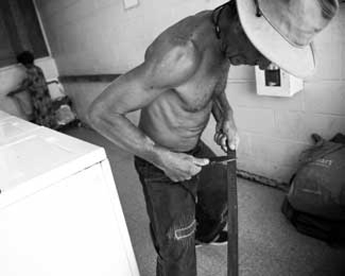 Alex sharpens his knife inside a community laundromat in the Chinatown District of Honolulu, Hawaii