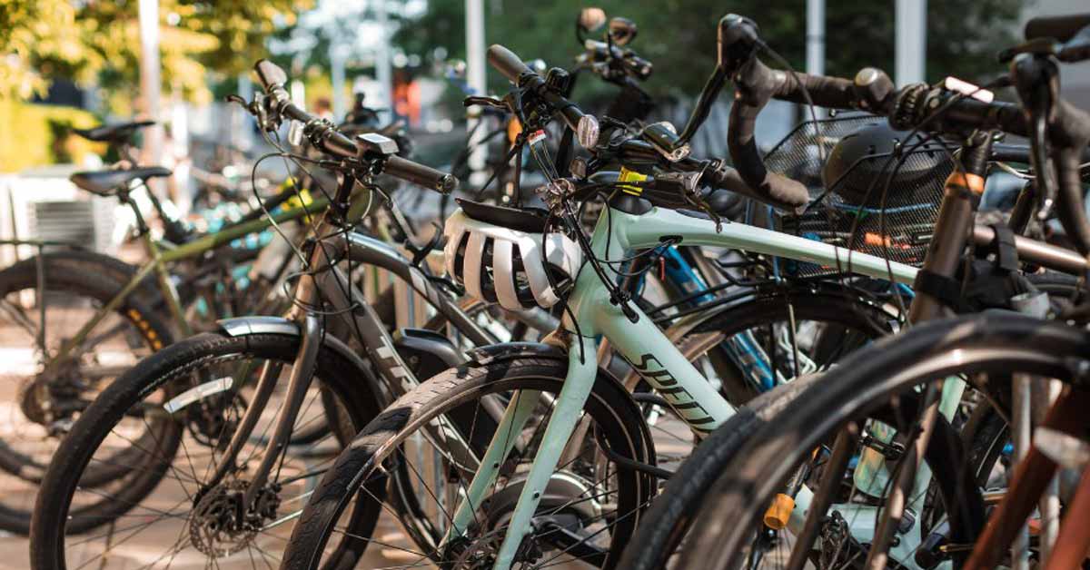 A group of bikes sit together in a bike rack