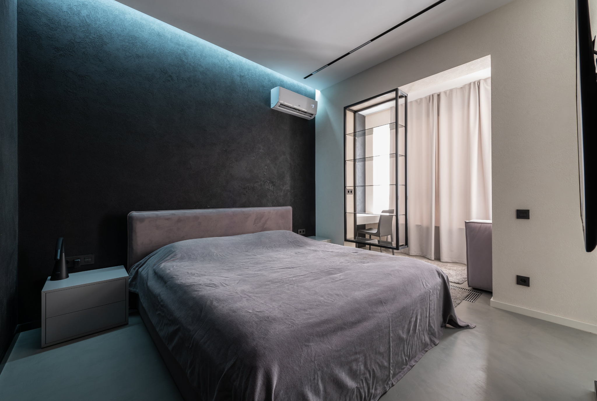 Modern bedroom with black walls, grey bed, and split-type air conditioner