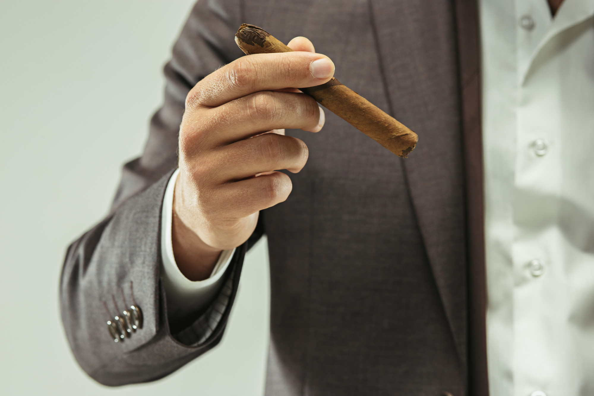 man in suit holding a cigar
