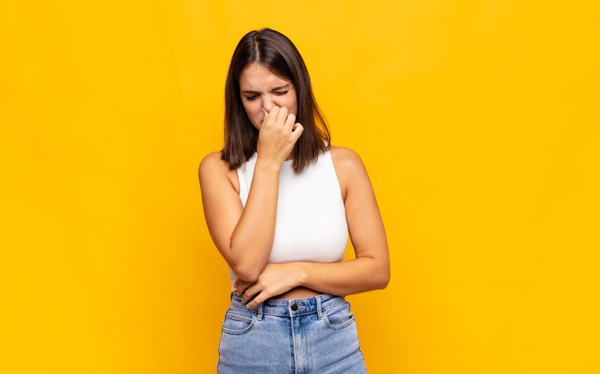 woman holding nose and grimacing