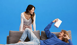 A young couple with the man lying on the couch