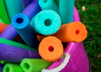 A bucket holding pool noodles