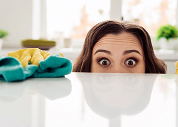 Lady looking for dust on a glass table