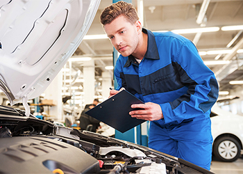 Mechanic looking under a car hood