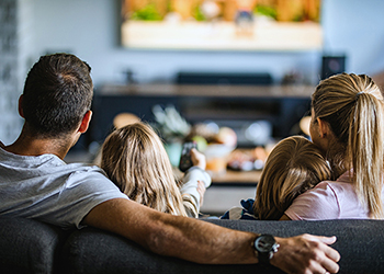 Rear view of family watching television
