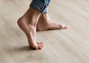 Person walking barefoot on floorboards