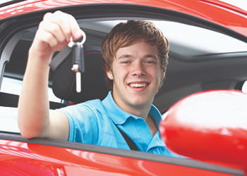 Young man in a car holding car keys