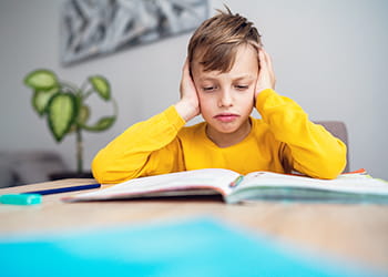 Young boy looking stressed by his homework