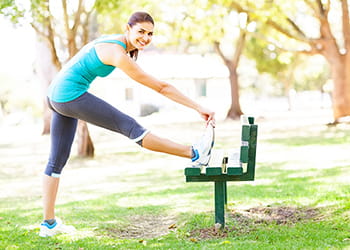 Woman stretchin on park bench