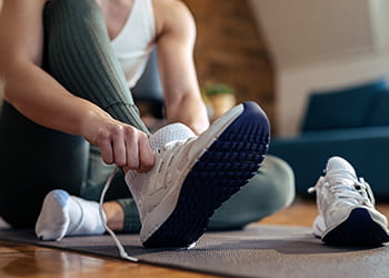 Woman putting on running shoes