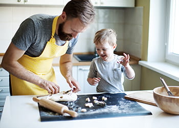 father and young son making biscuits