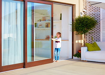 Young boy closing sliding glass door