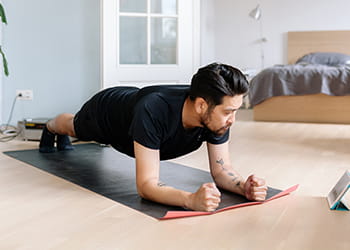 man exercising on mat at home