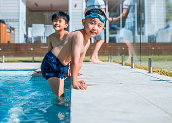 Two children in the pool with paved surrounds