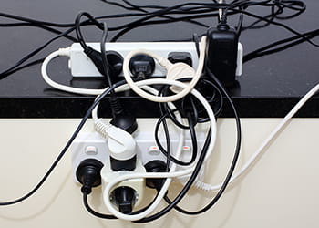 overloaded power outlet with adaptors and powerboard