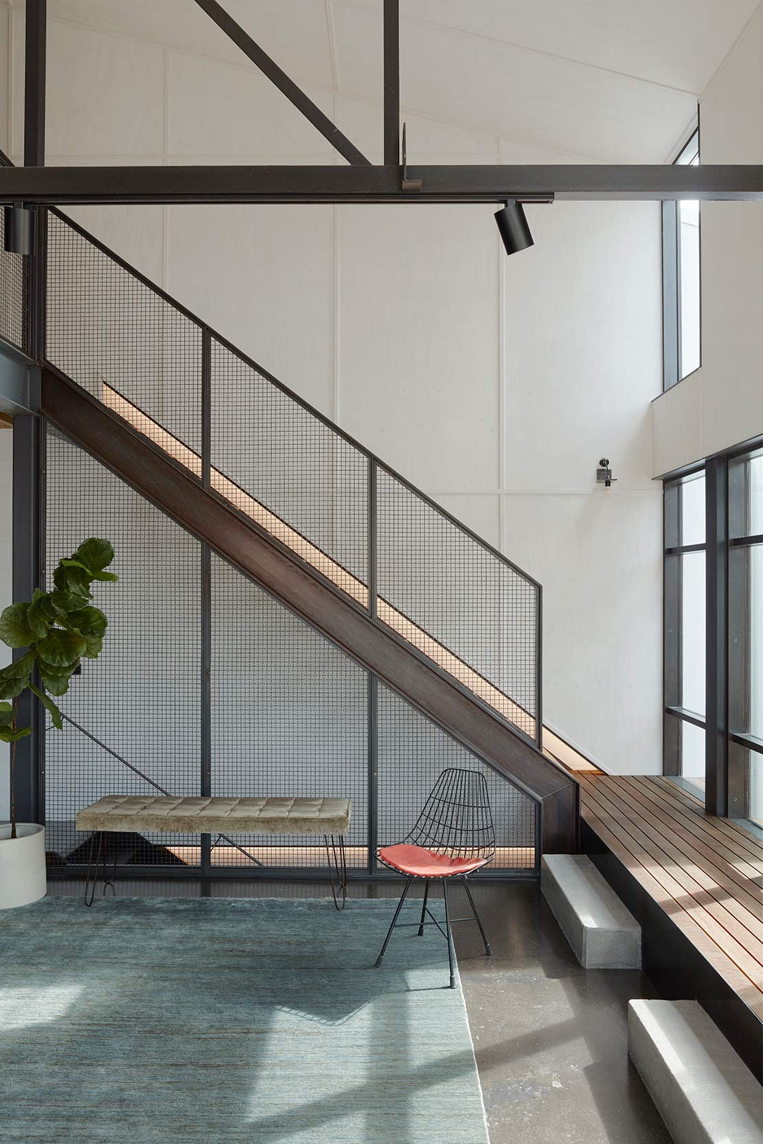 Side view of a steel-framed staircase leading to a timber-decked landing.
