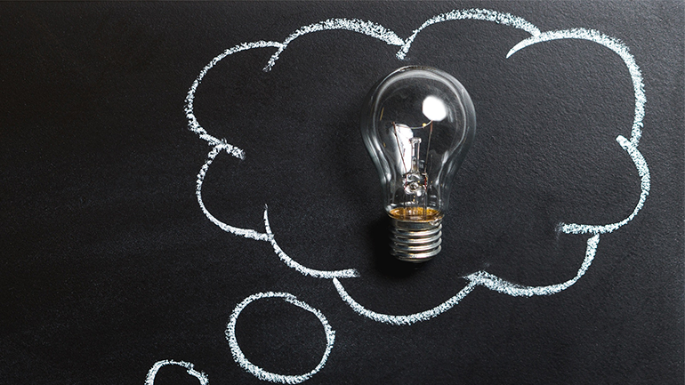 Image of a cloud drawn in chalk on a chalkboard with a real lightbulb inside.