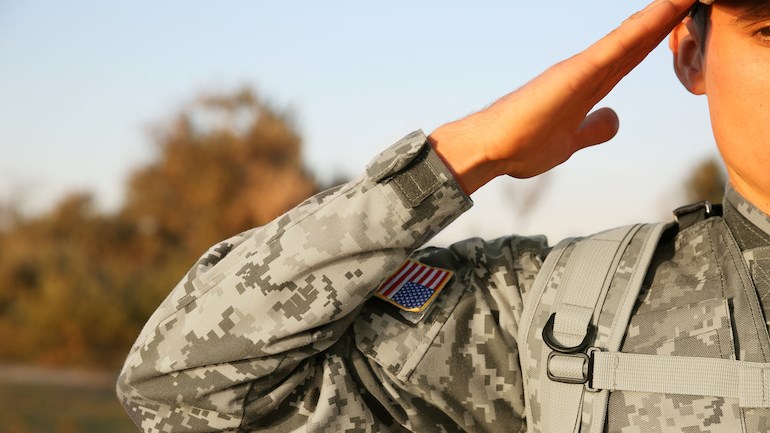 Closeup de um soldado dos EUA dando uma saudação de frente para a câmera.