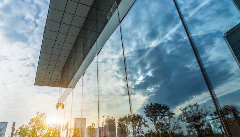 Exterior shot of a business building with big, glass windows.