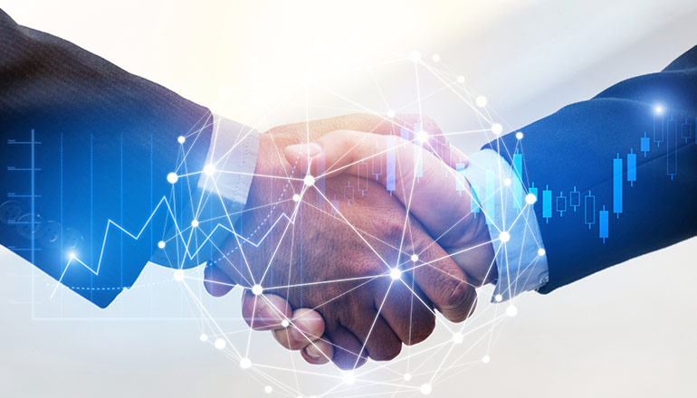 Closeup shot of two men in suits shaking hands.