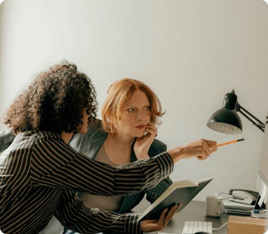 Two women collaborating on computer