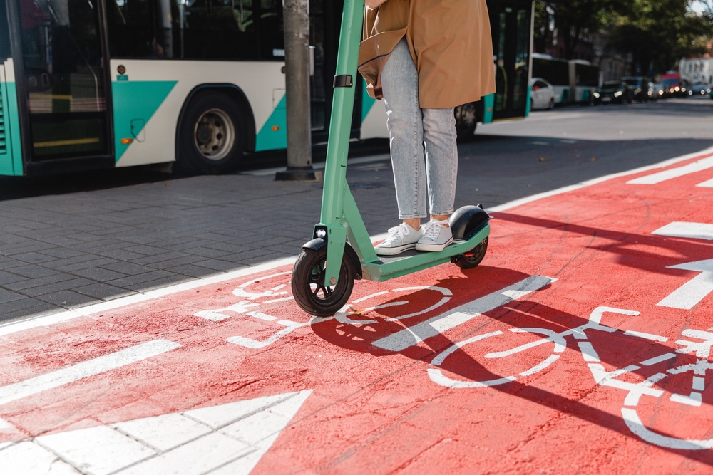 A person on a scooter driving on a bike path.