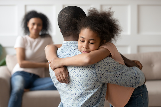A father and daughter hugging.