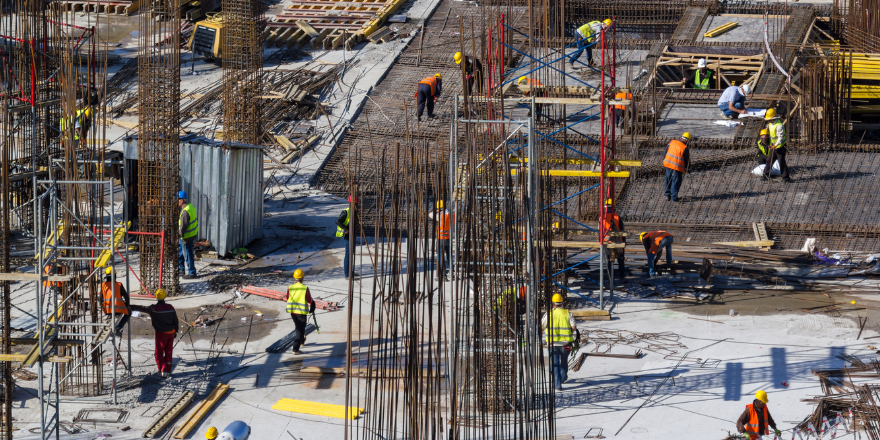 Multiple construction workers on site building with rebar.