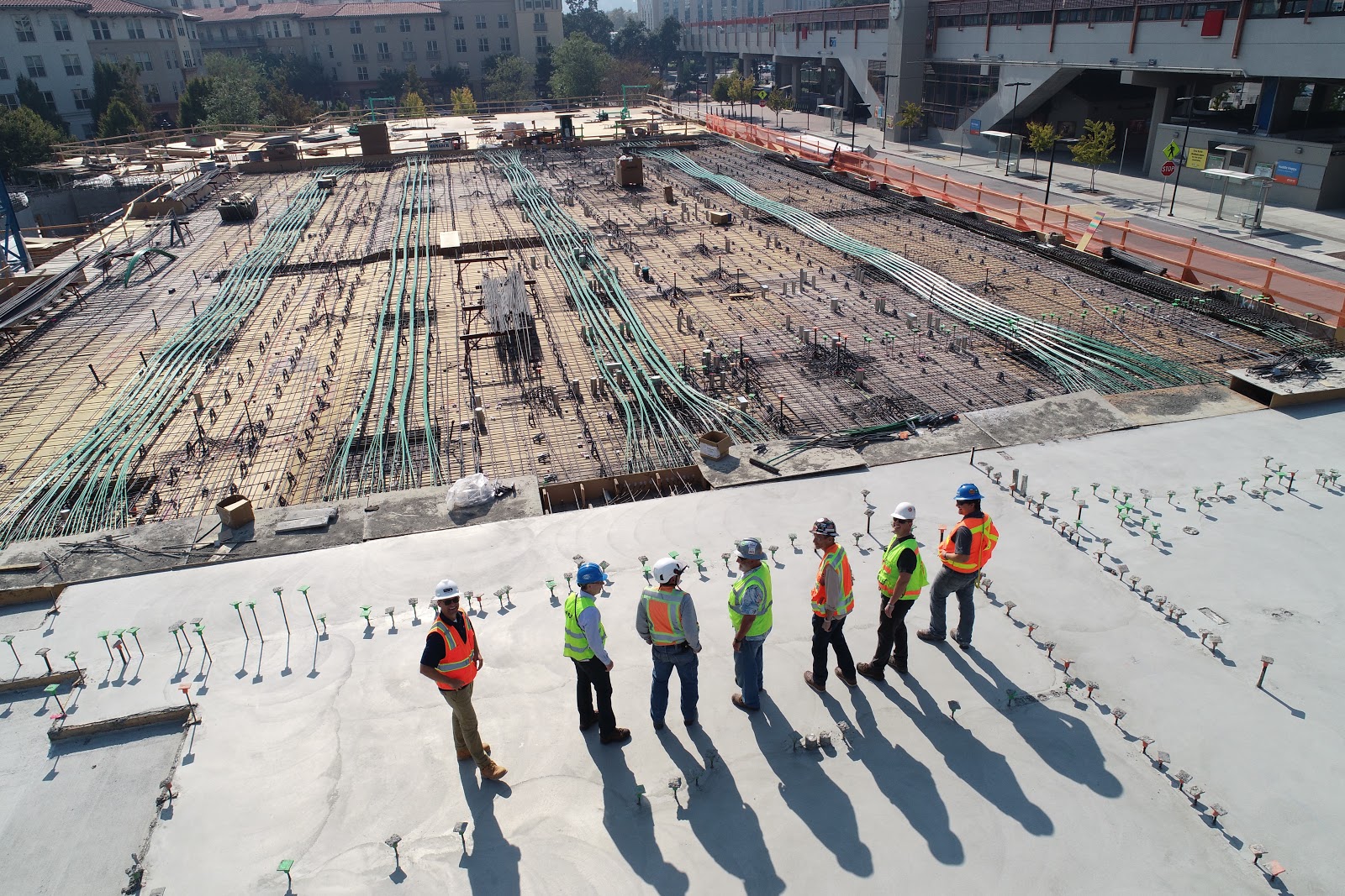 Seven construction workers on an electrical construction site standing in a row.