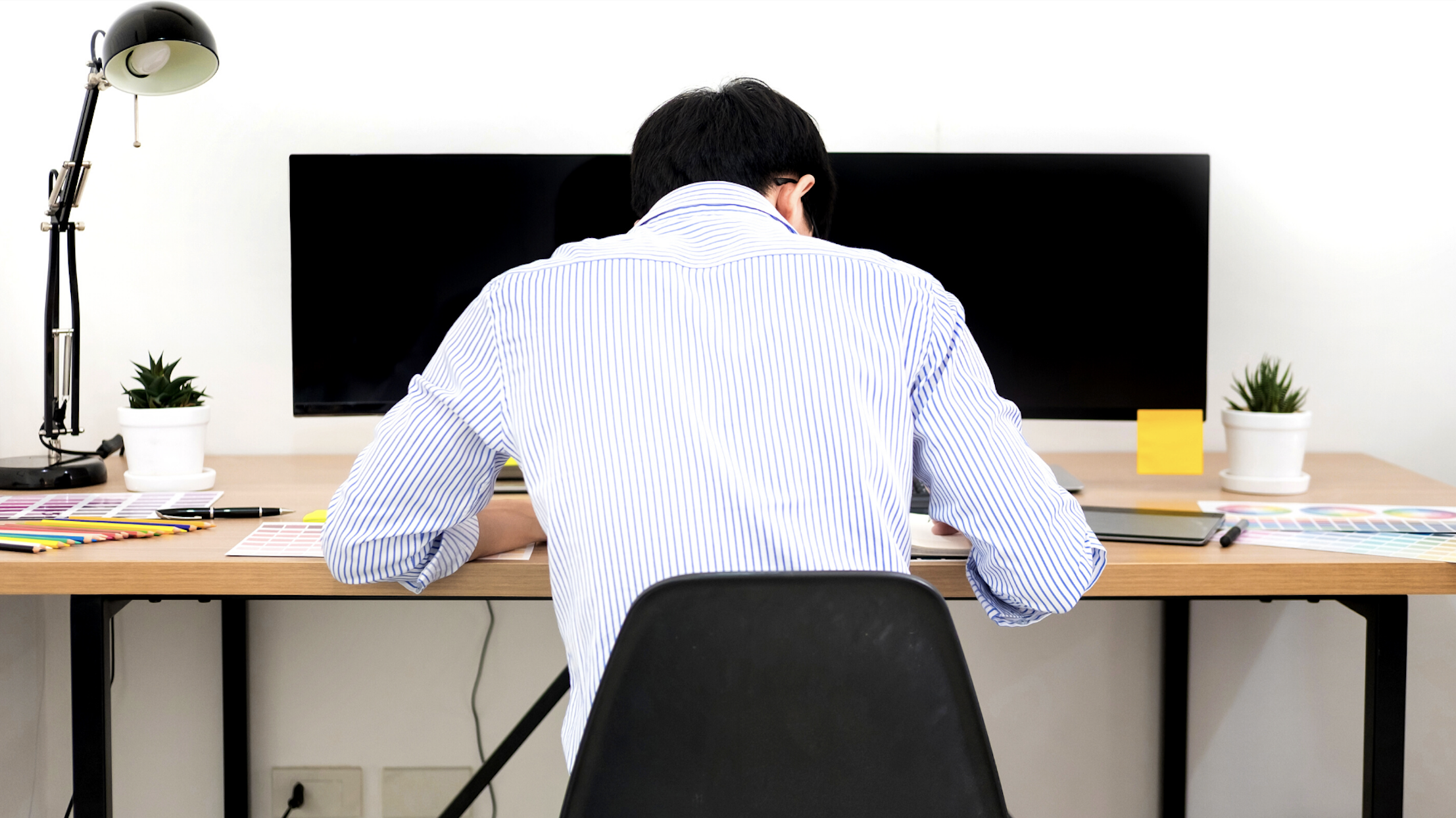 The back of a man working at a desk.