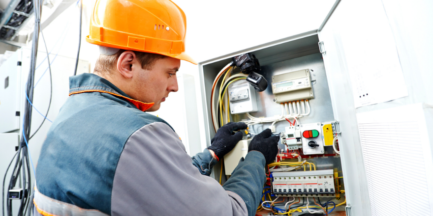 A electrical construction worker working on a electrical box.