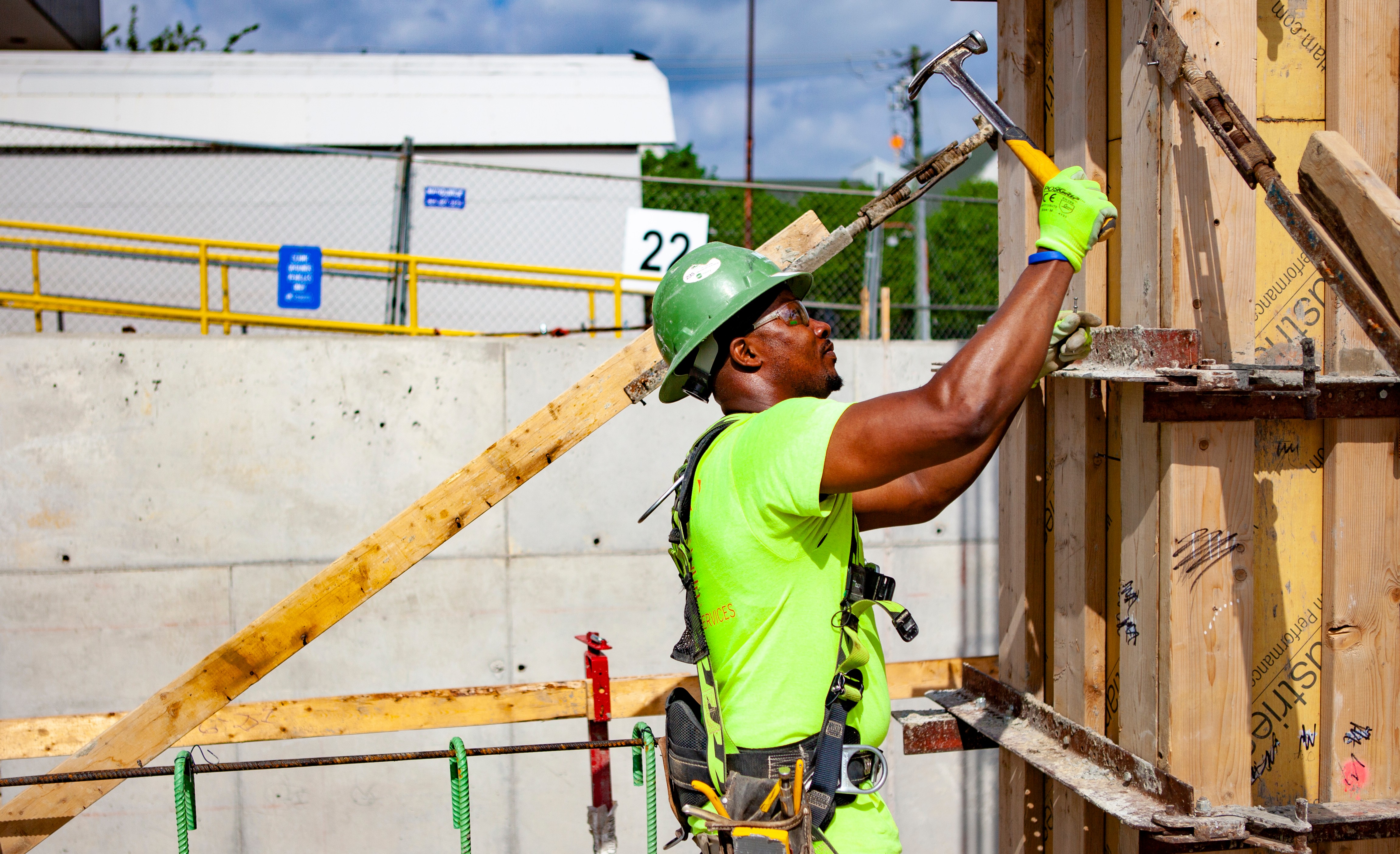 One construction worker hammering a board at a construction site.
