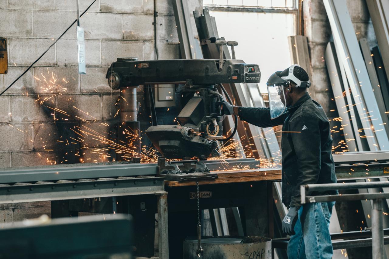 A construction worker using a metal chop saw on steel.