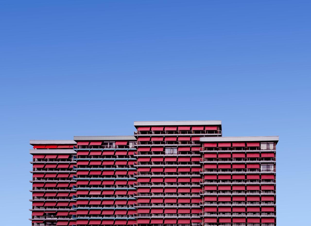 A series of four residential buildings with pink awnings.